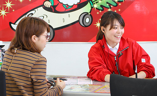 車検チェックインの受付をする女性